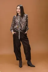 Camisa de gasa con estampado animal print abstracto en tonos marrones y beige, de corte clásico con cuello alto y lazo, cierre frontal abotonado y mangas largas con puños abotonados.