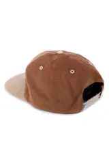 Gorra de pana color marrón con visera beige, con bordado de dos montañas rojas y un sol amarillo.