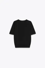 Jersey de punto fino con cuello redondo y manga corta, con terminaciones en rib en cuello, mangas y ruedo.