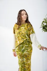 Buzo de mangas largas con estampado abstracto en tonos amarillos, verdes y marrones, con mangas color crema.