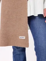 Bufanda de tejido de punto grueso en color negro, con etiqueta de la marca Rusty en uno de los extremos.