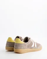 Championes Coolway modelo Baresi Urban Terra, inspirados en el fútbol indoor. Confeccionados en serraje y nylon efecto malla en tonos marrones, con bandas laterales blancas, detalle amarillo en el talón y suela de goma con amortiguación en gel.