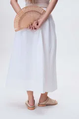Sandalias bajas de cuero color marrón con detalles de tachas metálicas.