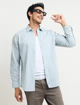 Camisa sport de manga larga con cuello buttondown, confeccionada en una mezcla de algodón y lino. Presenta un diseño clásico en color celeste con cierre frontal de botones.