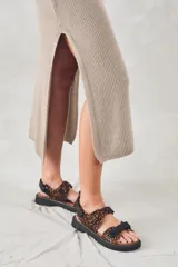 Vestido midi sin mangas, confeccionado en tejido de punto de algodón con textura tipo waffle. Presenta un corte recto, cuello redondo y aberturas laterales pronunciadas en el ruedo.