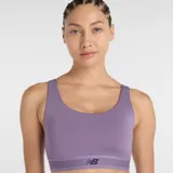 Top deportivo New Balance de impacto moderado, color lila, con cuello redondo y banda elástica inferior con logo de la marca. Confeccionado en tejido técnico de alto rendimiento con copas extraíbles.