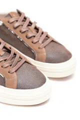 Zueco estilo sneaker marrón con cordones, suela plataforma de goma blanca y ribete interno de corderito sintético.