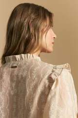 Camisa blanca de manga corta abullonada con terminación elastizada y cuello con leve frunce. Presenta una estampa floral integral.