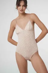 Body colaless de microfibra gloss con estampado de cebra en tonos beige y rosado. Presenta copas triangulares con bordes de puntilla, relleno extraíble, cierre en la entrepierna con broches de presión y breteles ajustables.