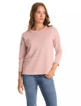 Buzo de punto color rosa, con escote a la base, mangas tres cuartos y diseño recto y holgado.
