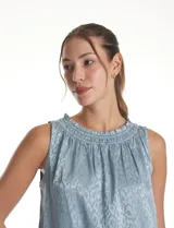 Blusa sin mangas de satén labrado color beige, con cuello a la base fruncido en punto smock.
