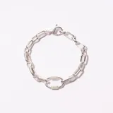 Pulsera de eslabones plateada con cierre de mosquetón y detalle central de eslabón ovalado con textura.