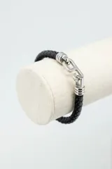 Pulsera de cuero trenzado color negro con cierre metálico plateado.