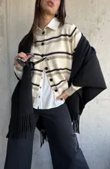 Cardigan de punto con diseño de rayas horizontales en tonos crema, beige y negro, con cuello redondo y cierre frontal de botones negros.