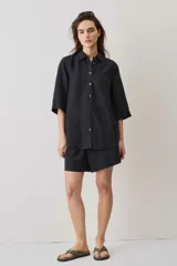 Short negro de tiro medio, confeccionado en lino, con diseño holgado y cierre clásico.