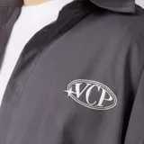 Camisa de manga corta color marfil, corte boxy, con cuello camisero, cierre frontal de botones y pequeño bordado marrón en el pecho con las siglas VCP.