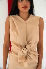 Vestido largo color beige, con breteles finos y detalle de lazo en el frente.