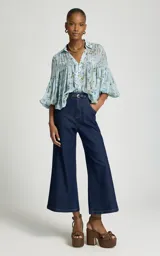 Jean flare corto de tiro alto, color azul oscuro, con cierre de botones y bolsillos delanteros.