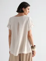 Remera blanca de lino con corte asimétrico y mangas cortas.