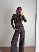 Top negro de mangas largas con estampado de líneas plateadas.