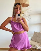 Conjunto de top y pollera lila con textura plumetie y volados. El top es corto con breteles finos y la pollera es corta con volados y lazo lateral.