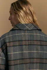 Tapado corto de lana con diseño a cuadros en tonos azul y negro, cuello camisero y cierre frontal con botones.