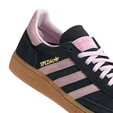 Championes Adidas Handball Spezial de corte bajo, confeccionados en gamuza negra con detalles en rosado en las icónicas tres tiras, cordones y talón. Presenta una suela de caucho color caramelo y el logo de la marca en dorado en el lateral.