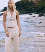 Pantalón pantalona confeccionado en tejido de punto abierto con elástico en la cintura y lentejuelas metalizadas aplicadas.