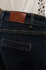 Short de jean azul oscuro, de tiro medio con bolsillos delanteros y traseros, costuras pespuntadas en contraste y dobladillo en las piernas.