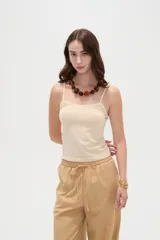 Musculosa de breteles finos confeccionada en poliamida, de corte ajustado al cuerpo y color beige.