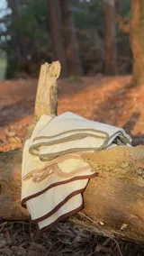 Ruana de lana afieltrada con bordes en contraste de colores oliva, beige y marrón. Diseño versátil y abrigado.