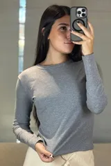 Remera de manga larga en color gris melange, con cuello redondo y ajuste entallado.
