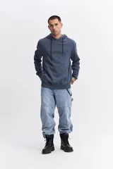 Canguro con capucha y cordones ajustables, de corte holgado y bolsillo frontal tipo canguro. Presenta un pequeño logo estampado en el pecho.