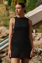 Vestido corto tejido sin mangas, con escote redondo y diseño de punto calado.