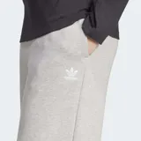 Pantalón Adidas de pernera ancha, color gris melange, confeccionado en suave tejido de felpa francesa. Cuenta con cintura elástica y el logo del trébol bordado en la parte superior delantera.