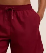 Bermuda deportiva masculina de color gris azulado, confeccionada en tejido técnico con textura perforada. Presenta cintura elástica con cordón de ajuste y diseño funcional para entrenamiento.
