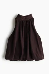 Cropped top halter de color marrón oscuro con leve brillo, escote alto con cuello elevado fruncido y diseño abullonado en el bajo.