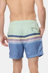 Short de baño con diseño rayado en la parte superior en tonos azul, amarillo, gris y celeste, y parte inferior de color azul sólido.