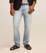 Pantalón slim de jeans celeste, con trabillas en la cintura, bolsillos y efecto desteñido.