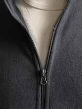 Campera de polar negra con cierre frontal completo, cuello alto, bolsillos laterales, puños elastizados y ajuste en la cintura.