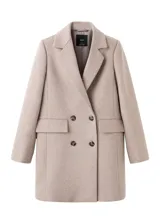 Abrigo de paño color beige, con diseño cruzado de doble botonadura, solapas clásicas y bolsillos laterales con solapa. Presenta un corte estructurado y elegante.