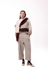 Pantalon de corte amplio y silueta relajada, con pinzas delanteras y cintura alta. Presenta un diseño estructurado con costura horizontal a media pierna.