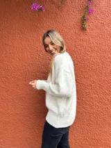 Sweater de punto en color crudo melange, con cuello redondo, mangas largas con puños ajustados y diseño de corte holgado.
