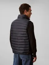 Chaleco acolchado tipo puffer de Calvin Klein, con cuello alto, cierre frontal con cremallera y diseño sin mangas.