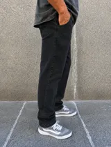 Pantalón de jean corte mom, color negro con efecto gastado, de tiro medio y calce holgado.