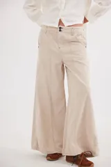 Pantalón de tiro medio confeccionado en pana de algodón, con diseño de corte sastrero y silueta amplia. Presenta bolsillos delanteros y traseros, con detalles de costuras verticales y combinación de tonos en los laterales.