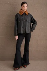 Camisa de cuero color tostado con cuello de corderito sintético, cierre frontal con botones a presión metálicos y bolsillos frontales con solapa.