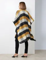 Ruana de tejido soft, marca Barrington, con diseño a cuadros grandes en tonos mostaza, gris oscuro y blanco. Presenta terminación en zig zag con lana en los bordes.