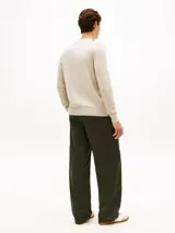 Sweater Tommy Hilfiger de cuello en V y manga larga, color beige, confeccionado en mezcla de algodón y poliéster. Presenta puños y bajo de punto canalé, con el logo de la marca bordado en el pecho.