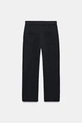 Pantalón de tiro medio color amarillo, con cintura elástica, bolsillos de plastrón en el delantero y pernera holgada que se estrecha hacia el tobillo. Cuenta con cierre frontal de cremallera y botón.